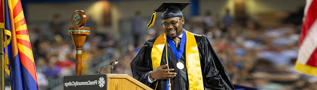 A Pima graduate smiles as he steps down from the podium at Graduation