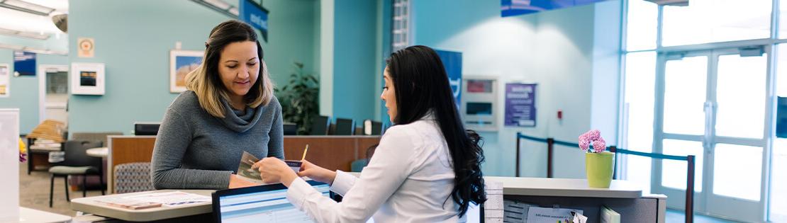 A Student Services Employee assists a student